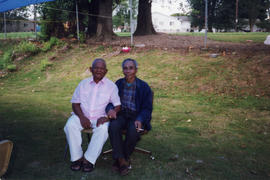 Two Community Members Sit Outdoors