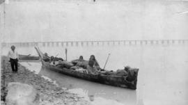 Family in longboat docked near shore